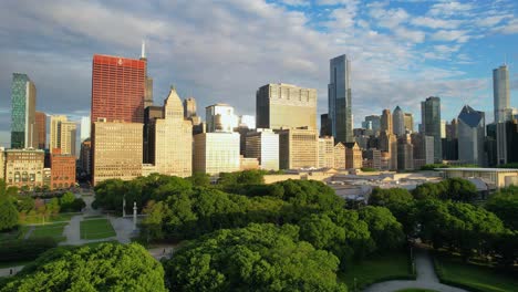 Drone-Over-Green-City-Park-Chicago-Skyline-Under-Cloudy-Morning-Sky