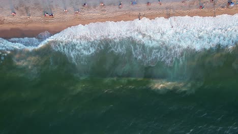 relaxing-view-of-green-ocean-waves-crashing-on-a-Mexican-beach-in-Puerto-Vallarta-at-sunset,-aerial-top-down