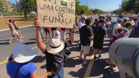 a-man-with-the-message-to-fight-against-the-evil-messiah-on-a-sign-he-is-holding-above-his-head-at-the-protest-against-the-murders-of-brit-dom-phillips-and-brazilian-bruno-pereira-in-the-amazon