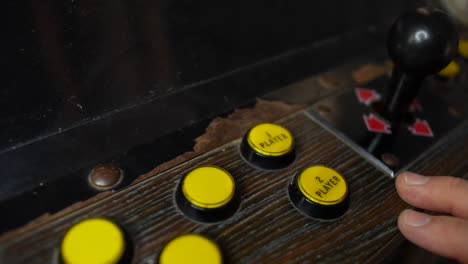 A-man-presses-player-one-button-on-an-arcade-machine