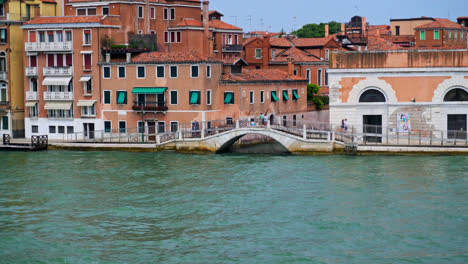 View-Of-Narrow-Canal-With-Bridge-In-Venice,-Italy---wide-shot