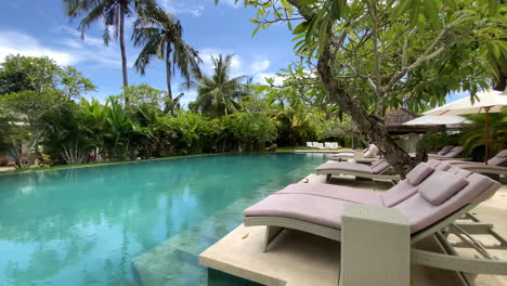 Row-Of-Empty-Sun-Loungers-Beside-Swimming-Pool-In-Luxury-Resort-In-Kuta,-Lombok