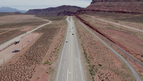 Cars-Traveling-through-Red-Sandstone-Valley-near-Moab,-Utah---Aerial