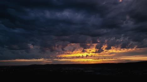 Panning-aerial-shot-of-a-bright-but-mysterious-sunset,-storm-rolling-in