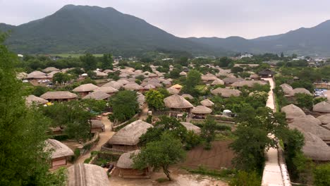 Aerial-panorama-shot-of-traditional-village-in-South-Korea-in-rural-landscape-with-mountains-during-clouds-at-sky---Naban-Eupseong-Folk-Village