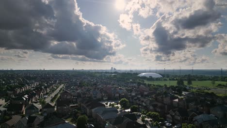 A-wide-drone-shot-of-a-suburban-town-,-sunny-and-cloudy,-jibbing-from-high-to-low