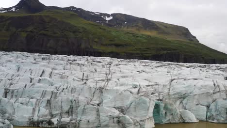 Glaciar-En-Islandia-Con-Montañas-Con-Video-De-Drones-Moviéndose-De-Cerca