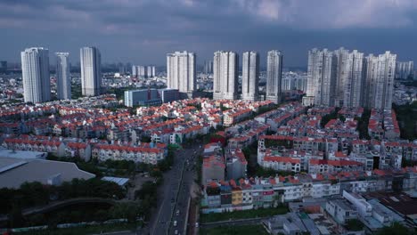 Aerial-shot-of-modern-urban-and-high-rise-development-area-of-Ho-Chi-Minh-City,-Vietnam-with-dramatic-afternoon-sky