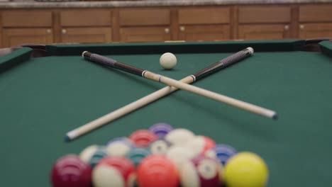 billiards-pool-table-with-crossed-pool-cues-in-a-game-room