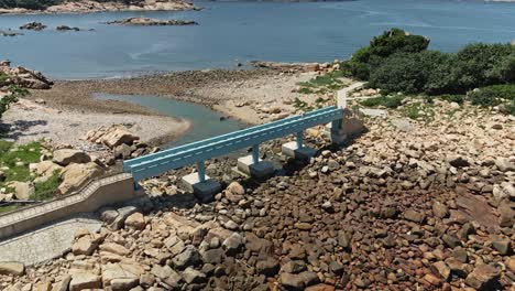 Aerial-view-of-the-blue-Lover-Bridge-in-Shek-O,-Hong-Kong,-low-sea-level