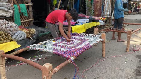 Ein-Arbeiter-Bindet-Ein-Seil,-Um-Ein-Nachhaltiges,-Erschwingliches-Holzbett-Vorzubereiten