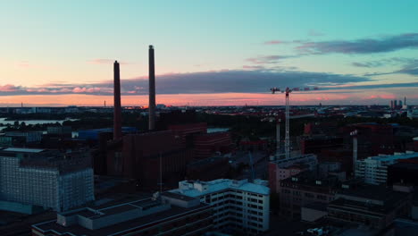Aerial-view-around-the-Helen-Oy,-Salmisaari-power-plant-in-Ruoholahti,-dusk-in-Helsinki,-Finland---circling,-drone-shot