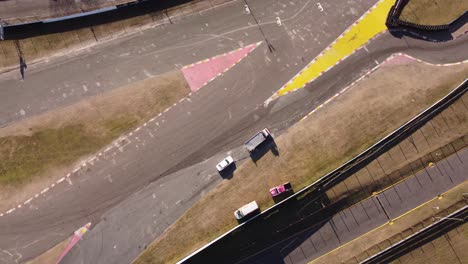Aerial-top-down-view-of-towing-truck-clearing-the-race-track-by-removing-the-broken-vehicles