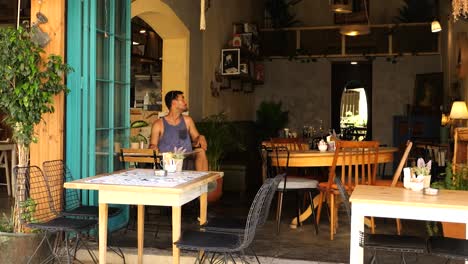 Male-Tourist-Sitting-Alone-In-Cafe-Looking-Around-In-Nicosia,-Cyprus