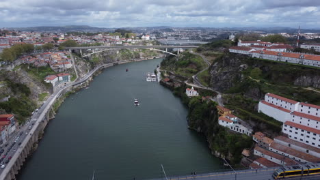 Antena-Volando-Hacia-Atrás-Sobre-El-Río-Douro-Revelando-La-Ciudad-De-Porto,-Portugal