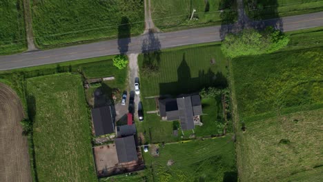 Drohnen-Zoom-Ansicht-Von-Kleinen-Häusern-Und-Autos,-Die-Auf-Dem-Bauernhof-Geparkt-Sind