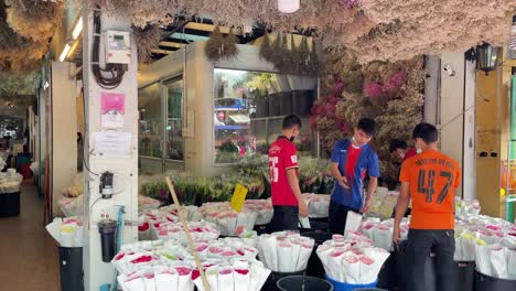 Men-preparing-bouquets-of-flowers-at-Bangkok's-flower-market,-Pak-Khlong-Talad