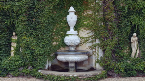 Italienischer-Griechischer-Oder-Englischer-Steinwasserbrunnen-Mit-Statuenskulpturen-Und-Reben