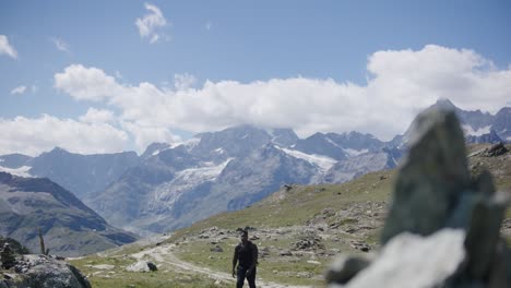 Black-male-traveler-with-backpack-exploring-the-mountain-landscape-near-the-Matterhorn-in-Switzerland
