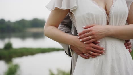 Wedding-couple-embracing-by-the-river-during-a-photo-video-session