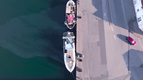Eine-Luftaufnahme-Von-Fischerbooten,-Die-An-Einem-Sonnigen-Frühlingsabend-Am-Pier-In-Einem-Kleinen-Hafen-Festgemacht-Sind