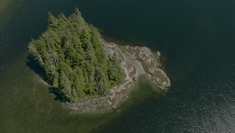 Drone-footage-top-down-a-small-island-in-a-bay-on-the-pacific-ocean-near-Vancouver-Island,-British-Columbia-Canada