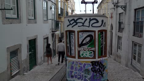 Die-Mit-Graffiti-Bemalte-Umgebaute-Straßenbahn-Sitzt-Im-Späten-Frühling-In-Der-Schmalen-Straße-Von-Lissabon