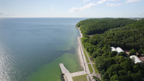 Aerial-Bastic-sea-coastline-with-a-view-of-Feliks-Nowowiejski-Seaside-Boulevard-lealing-to-the-Gdynia-city-public-beach-by-dense-forestery-Green-Park
