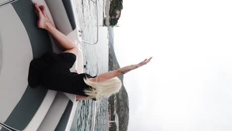 A-young,-attractive-caucasian-woman-dressed-in-a-black-dress-is-sitting-and-looking-out-into-the-Adriatic-Sea-from-the-speedboat,-Croatia
