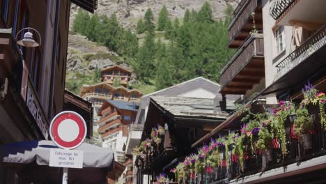Slow-plan-up-from-colorful-vibrant-luxury-restaurant-towards-mountains-in-Zermatt,-Switzerland