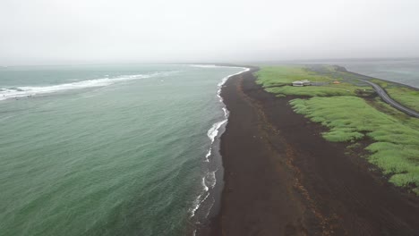 Playa-De-Arena-Negra-En-Islandia-Con-Hierba-Verde-Con-Video-De-Drones-Moviéndose-Hacia-Abajo