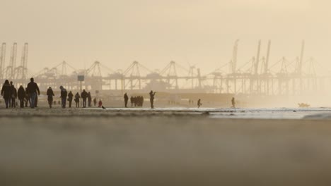 Schöne-Stimmungsvolle-Filmische-Aufnahme-Von-Silhouettierten-Menschen-Am-Haken-Des-Holländischen-Strandes