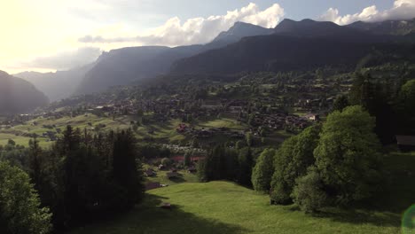 aerial-drone-footage-pushing-in-over-alpine-meadows-revealing-views-of-Grindelwald-at-sunset