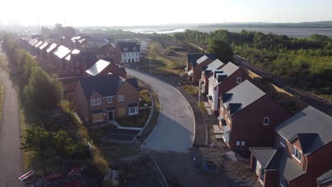 Aerial-view-morning-sunrise-over-British-suburban-townhouse-development-building-site