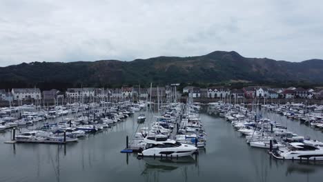 Aerial-rising-view-above-wealthy-luxury-yachts-and-sailing-boats-moored-in-quaint-Conwy-town-marina