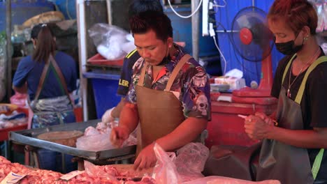 Butcher-cutting-meat-at-market-stall-in-Bangkok
