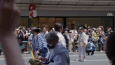 Japanese-Men-in-Gion-Festival-Costumes-Standing-in-Streets-and-Crowds-Wait