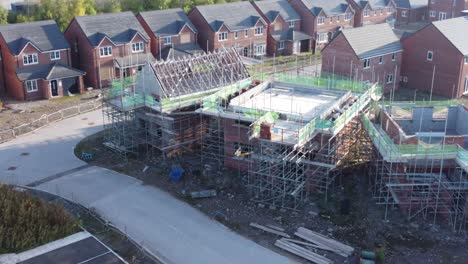 Aerial-view-panning-across-new-build-housing-framework-on-construction-site-development