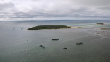 Aerial-left-to-right-parallax-around-old-fishing-boat-shipwrecks-stranded-in-shallow-water-off-Tongatapu