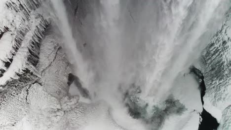 Ein-Wunderschöner-Großer-Wasserfall-In-Island-Mitten-Im-Winter,-Bedeckt-Von-Schnee-Und-Den-Wolken,-Macht-Es-Noch-Besser