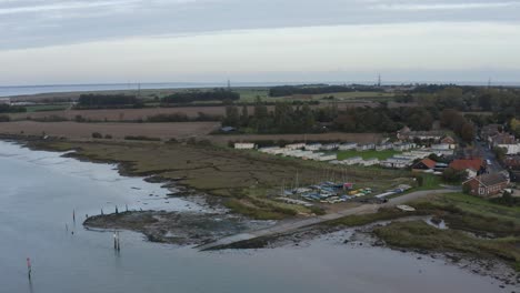 Moored-boats,-mobile-homes-and-other-buildings-on-the-waters-edge-at-Bradwell