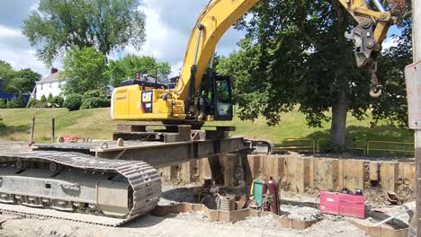 Man-attaches-large-chain-to-arm-on-excavator