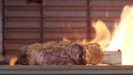 Slow-Motion-Close-Up-Of-Rare-Peppered-Beef-Steak-On-Flaming-Barbecue-Grill,-4K