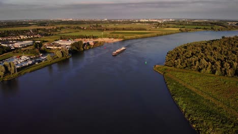 Aerial-View-Of-FPS-Waal-Cargo-Container-Vessel-Approaching-River-Bend-On-Oude-Maas