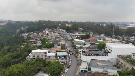 Aerial-drone-forward-moving-shot-of-rooftops-in-the-town-of-Santa-Catarina-Palopo,-Guatemala-city-on-a-cloudy-day