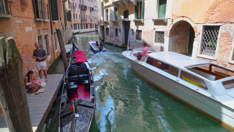 Motorboats-Passing-By-In-A-Narrow-Venice-Canal-In-Italy---handheld