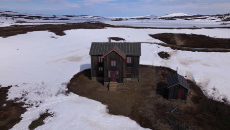 Drone-shot-aerial-footage-of-the-Storwartz's-old-house-in-Roros,-Norway's-wintery-landscape