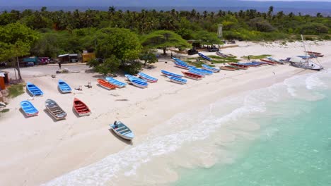 Aerial-view-of-tropical-sandy-beach-with-many-parking-boats-and-turquoise-Caribbean-Sea