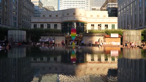 Canary-Wharf-London-England-June-2022-Pride-tribute-sculpture-standing-by-the-Cabot-Square-fountain-with-the-reflection-playing-back-across-the-water