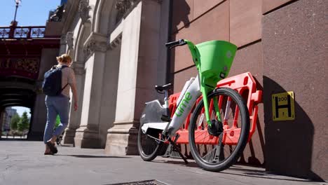 London-Farringdon-UK-Aug-2022-Lime-bike-rests-against-building-wall-waiting-for-use
